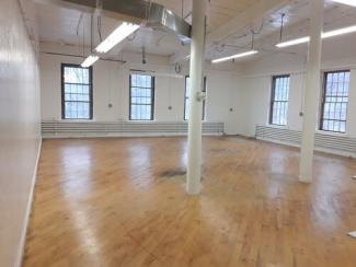 Large bright studio with wood floors and high windows