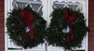 Image of 2 evergreen wreaths on a white door