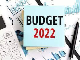calculator and graphs with blue post it that reads Budget 2022